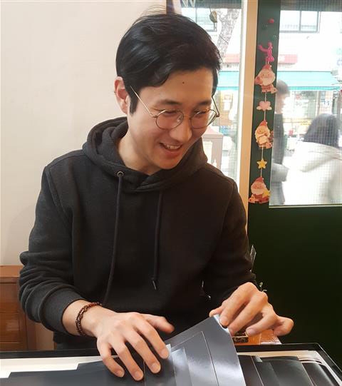 참전용사 기록 작업을 펼쳐보는 사진작가 김승우